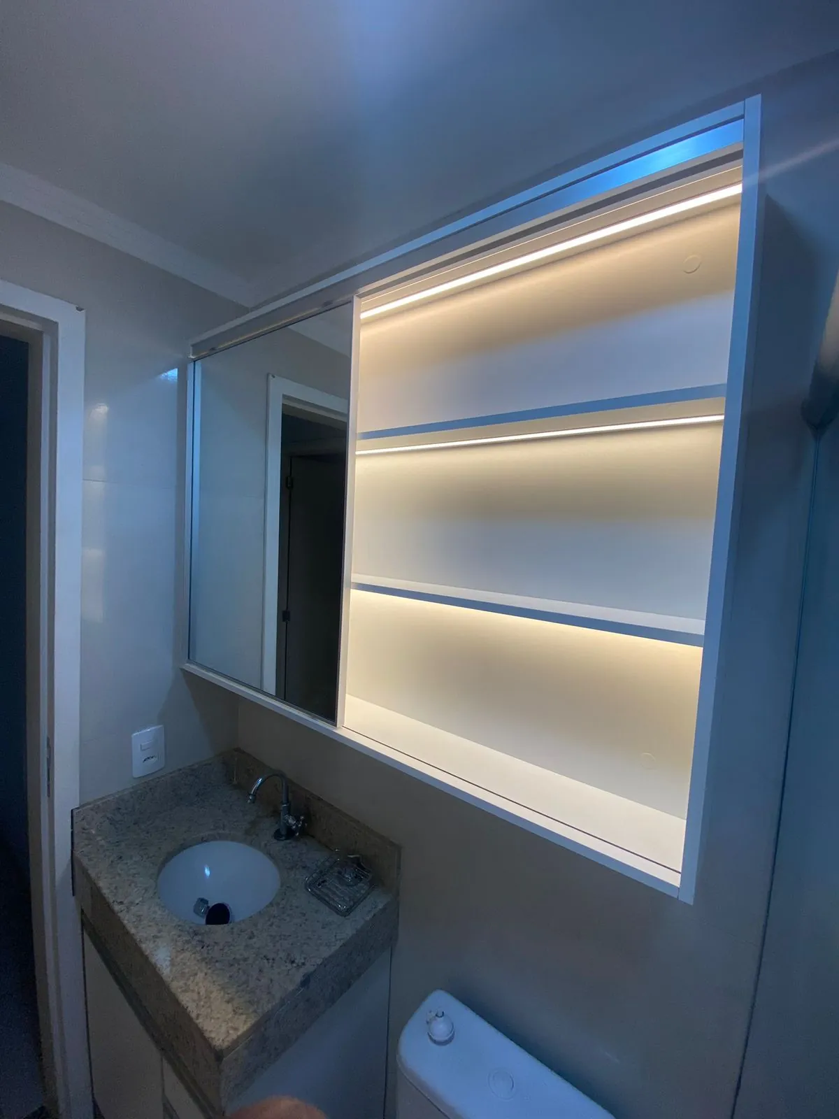 Armário de banheiro branco com iluminação embutida — projeto Tubias