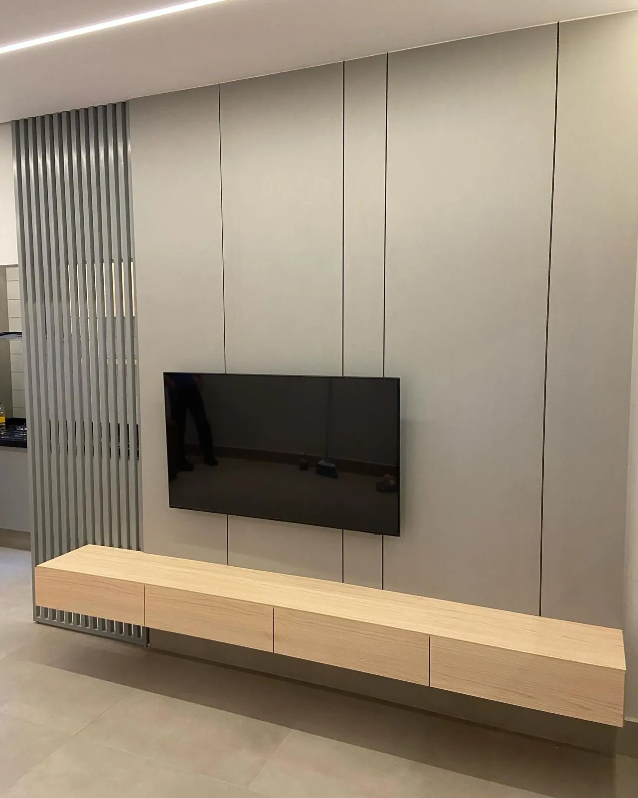 Painel planejado claro com ripas e rack suspenso — projeto Tubias