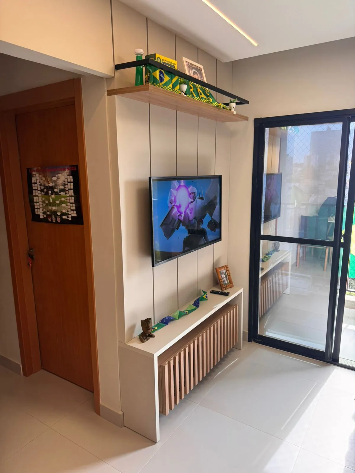 Sala compacta com painel de TV planejado e prateleiras — projeto Tubias